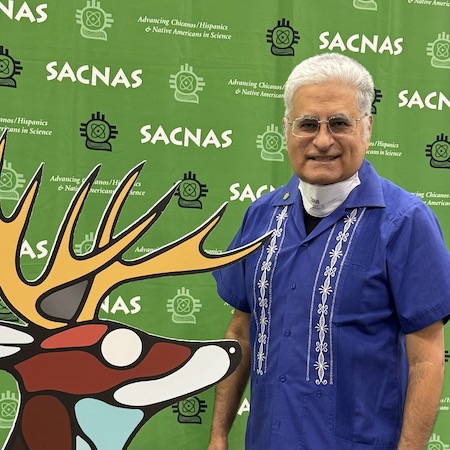 SACNAS 2025- Roca selfie in front of conference poster